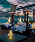 Outdoor restaurant with Cordless Gold Battery Operated Table Lamp For Dining Ambience on tables overlooking waterfront.