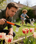Man using Extended Reach Powder Duster Wand System for uniform dusting on tulips in garden, child and dog in the background