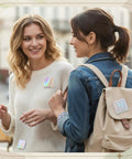 Two women wearing square badges made with 200 Pcs Button Maker Film Kit With Glittering Holographic Sheets For 50 Mm Badges.