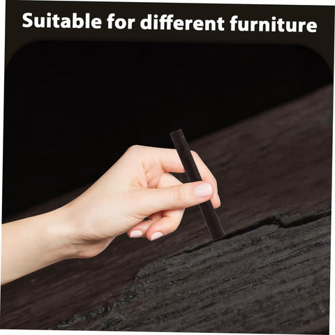 Hand using 2 Pack Wood Filler Sticks for Furniture Repair Scratch Remover Pens Quick Fix Paint Markers on wooden surface