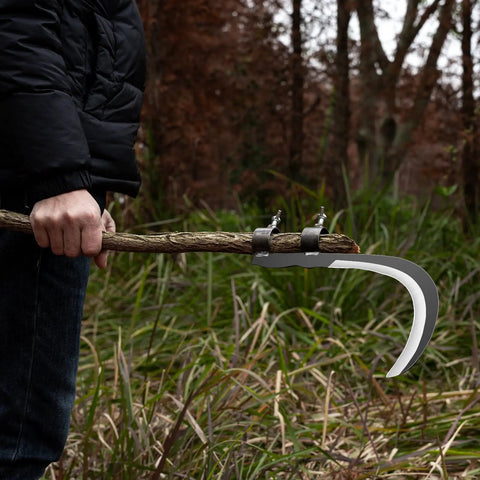 Person holding All-Purpose Garden Sickle With Replaceable Wooden Handle And Heavy-Duty Manganese Steel Blade for yard cleanup
