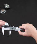 Hands using 6 Inch Digital Caliper With Stainless Steel Polished Finish, Inch Millimeter And Fraction Readouts on metal part