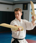 Man practicing with Natural Hardwood Wing Chun Butterfly Swords Set For Kung Fu Training in dojo