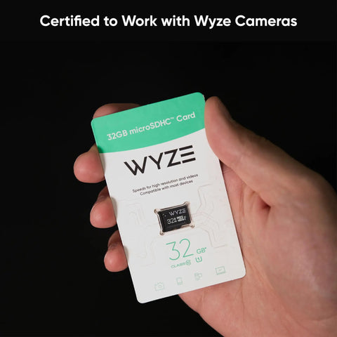 Hand holding a Wyze-certified Expandable 32GB MicroSDHC Card Class 10 UHS-I U1 for Cameras and Dash Cams with packaging.