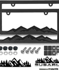 Two Pack Black Plastic Mountain License Plate Frames With Three Dimensional Mountain Design Includes Mountain Vinyl Sticker Screws And Caps For Your Ride Adventure Ready For Off Road And Hiking Fans displayed with accessories