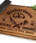Front view of wooden cutting board with engraved BBQ design, knives motif, and rosemary sprig