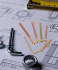 Assorted screws from 49-Piece M6 Hex Socket Screws and Barrel Nut Set for Furniture Repair placed on a blueprint