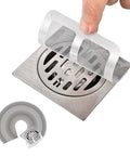 Fifty Pack Disposable Drain Sticker Hair Catcher That Hits Different With Heavy Duty Mesh and Straight Up Kicks Clogs To The Curb For Showers Sinks And Bathtubs Easy Peel Adhesive Screen displayed over a stainless steel drain.