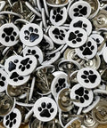 White Paw Print Upholstery Tacks 100 Piece Kit flat decorative pins with black paw designs for furniture projects and crafts.