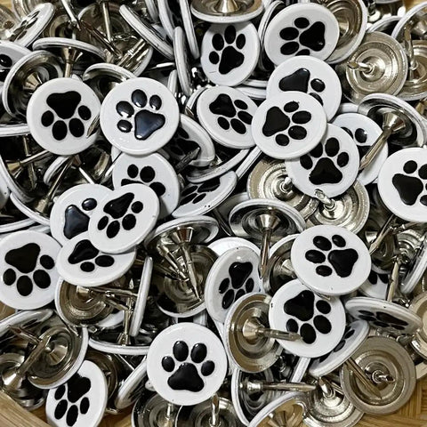 White Paw Print Upholstery Tacks 100 Piece Kit flat decorative pins with black paw designs for furniture projects and crafts.