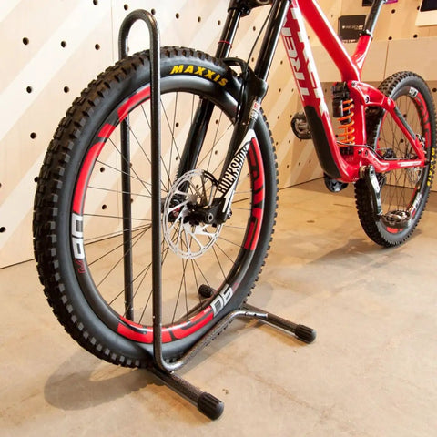 Portable Single Bike Stand For 20 To 28 Inch Wheels And Up To 2.5 Inch Wide Tires, holding a bike in a garage setting.