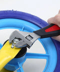 Adjustable wrench from 245-Piece Mechanics Tool Set And Socket Kit tightening bolt on blue wheel
