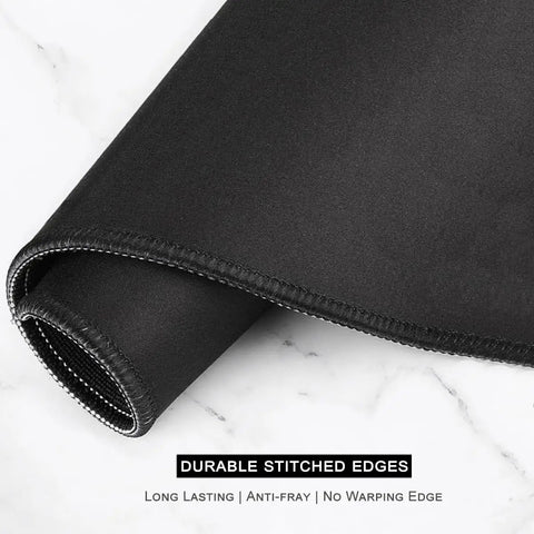 Close-up of the durable stitched edges of Ultra Large Green Tropical Leaves Desk Pad For Keyboard, Laptop And Computer, XXL Gaming Mouse Pad.