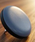 Close-up of 16 Pack 1 Inch Nail-On Furniture Sliders For Wooden Furniture Legs PTFE Chair Glides on a wooden surface