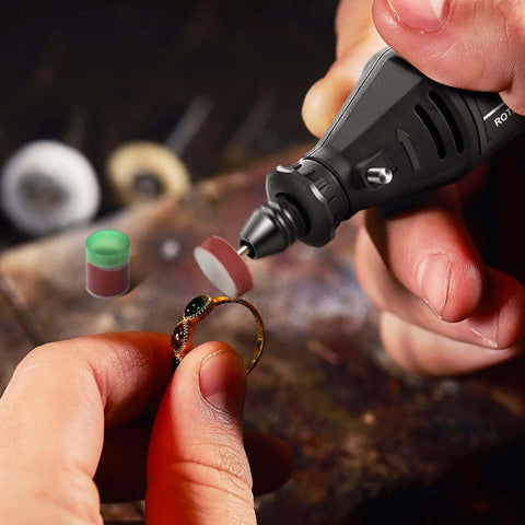 Close-up of GOXAWEE rotary tool polishing a gold ring with a buffing wheel; small green-lidded compound jar visible.