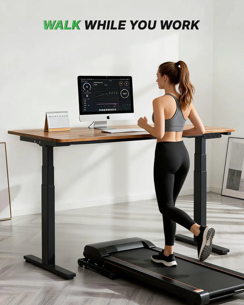 Woman using treadmill with Dual Motor 3-Stage Standing Desk Frame With Electric Height Adjustment, Sit Stand DIY Desk Legs Up To 80 Inch By 31.5 Inch, Heavy Duty 300 Lb Capacity, Memory Controller, Black Frame