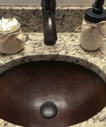 Close-up of Oil Rubbed Bronze 1.5 Inch Non Overflow Pop Up Bathroom Sink Drain with Push Pop Top Design in granite vanity.