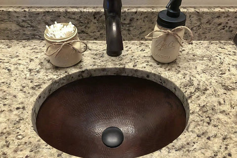 Close-up of Oil Rubbed Bronze 1.5 Inch Non Overflow Pop Up Bathroom Sink Drain with Push Pop Top Design in granite vanity.