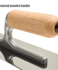 Close-up of Pro Grade Stainless Steel Venetian Plaster Trowel with textured wooden handle and beveled edges, polished finish.