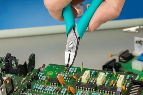 5 Inch Angled Tip Cutter With Ergonomic Co Molded Grip For SMT Lead Trimming, Durable Eremadium Tool Steel, EMOS Stop, Precision Electronics Pliers For Circuit Boards And Fine Wire Work being used on a circuit board.