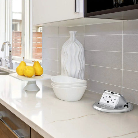 Round Pop Up Floor Outlet Box With 20 Amp USB Tamper Resistant Receptacle ETL Listed on kitchen countertop next to decor