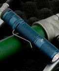 Quark LED Flashlight Pocket EDC With Clip, High CRI Beam on green background, focusing on compact design and clip attachment.