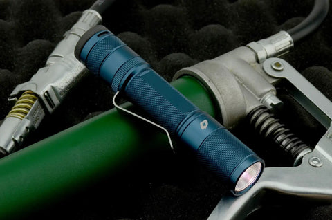 Quark LED Flashlight Pocket EDC With Clip, High CRI Beam on green background, focusing on compact design and clip attachment.