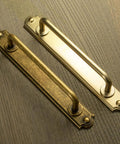 Antique Brass Drawer Pulls With Backplates Five Point Zero Four Inch Center To Center Zinc Alloy Cabinet Handles on wood surface