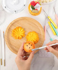 Acrylic Cookie Decorating Turntable Kit in use: decorated cookies, brushes, and scribe needles on a wooden platter.