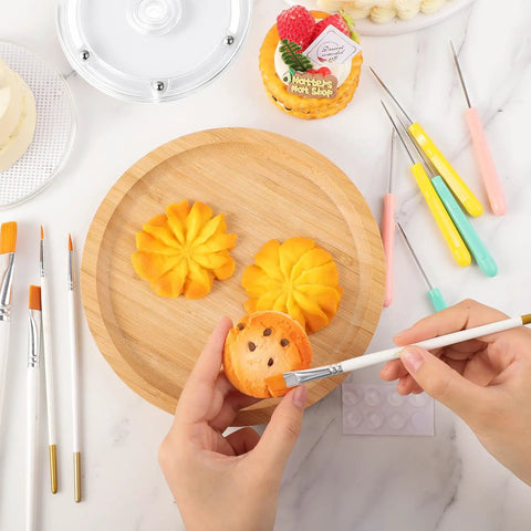 Acrylic Cookie Decorating Turntable Kit in use: decorated cookies, brushes, and scribe needles on a wooden platter.