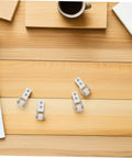 Six Pack Nylon Guide Wheels In Clean White For Furniture Track Systems And Drawer Hardware on a wooden table with coffee items.