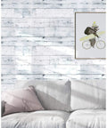 Living room with Peel And Stick Wood Shiplap Wallpaper In Light Grey White And Blue Distressed Planks above a light gray sofa.
