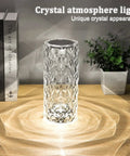 Crystal Diamond Night Light Lamp With 16 RGB Colors And 4 Modes on wooden table next to books and plant.