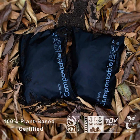 Two 12x15.5 Inch Biodegradable Shipping Bags 50 Count Compostable Poly Mailers on fallen leaves, eco-friendly packaging.