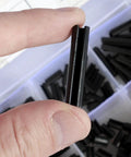 Close-up of Garage Ready 430 Piece Roll Pin Assortment Kit Pro Grade Carbon Steel Slotted Spring Pin held between fingers.