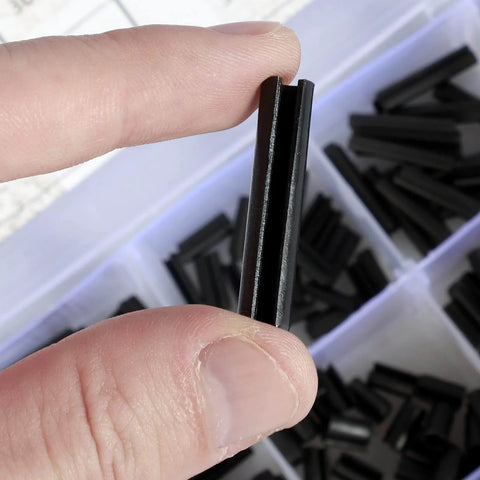 Close-up of Garage Ready 430 Piece Roll Pin Assortment Kit Pro Grade Carbon Steel Slotted Spring Pin held between fingers.