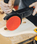 10 Pcs Orange Nylon Hook And Loop Electric Sanding Discs 2000 Grit for polishing wood with a power sander on a workbench.
