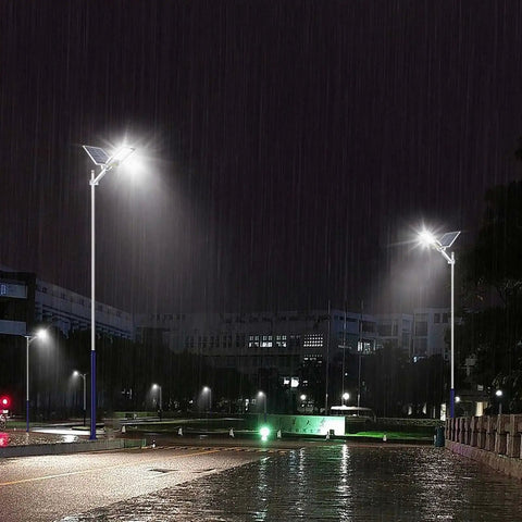 JUDYSSY Outdoor Solar Powered Street Flood Lights-400W Dusk to N in the rain, illuminating a dark street with remote control features.
