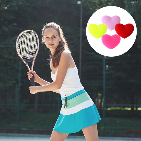 Woman playing tennis with heart shaped tennis dampeners set of 4 silicone vibration absorbers for rackets in red pink yellow purple
