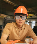 Person wearing Tough As Nails Heavy Duty Welding Goggles Six Pack Plastic Safety Glasses with orange hard hat.
