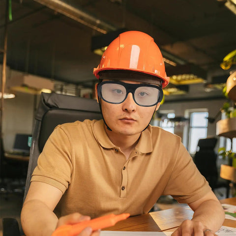 Person wearing Tough As Nails Heavy Duty Welding Goggles Six Pack Plastic Safety Glasses with orange hard hat.