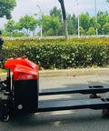 Heavy Duty Electric Pallet Jack Truck with Hydraulic Power For Efficient Warehouse Loading And Unloading 1500kg Capacity robust forklift showing side view with control handle.