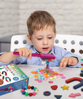 Child playing with 122 Piece Magnetic Science Kit for Kids with colorful chips, magnetic balls, wands, and rings on a table.