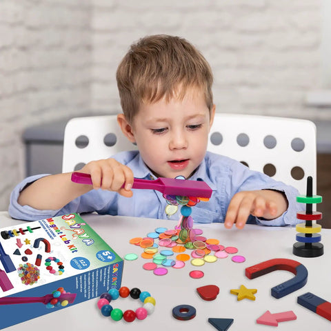 Child playing with 122 Piece Magnetic Science Kit for Kids with colorful chips, magnetic balls, wands, and rings on a table.