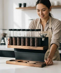 Woman holding a Two Tier Wooden Coffee Bean Storage Rack With Airtight Glass Jars Featuring Black Vent Lids countertop setup.