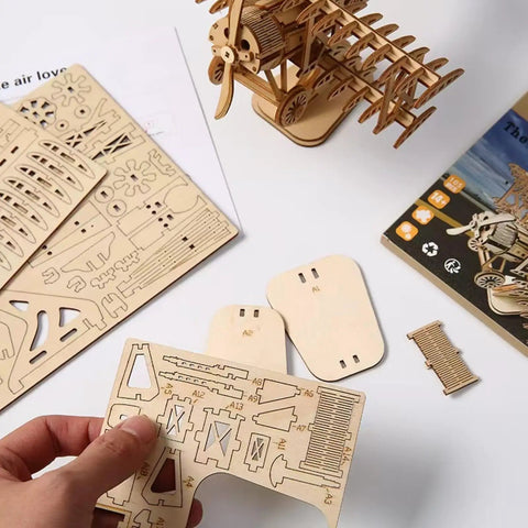 Adult 3D Wooden Jigsaw Puzzle Kit with airship model parts and assembly instructions on a desk.