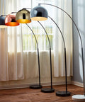 Multiple arc floor lamps with faux black marble bases and bell shades in a bright room.