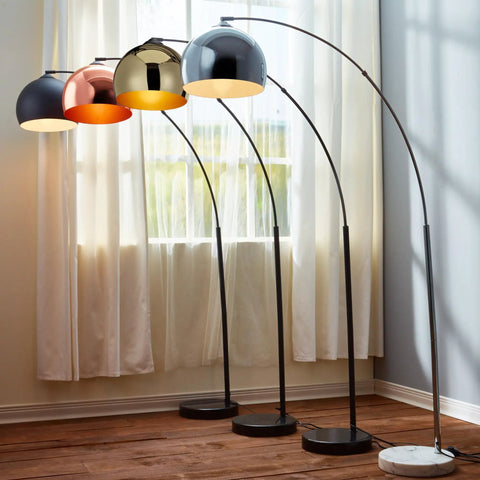 Multiple arc floor lamps with faux black marble bases and bell shades in a bright room.