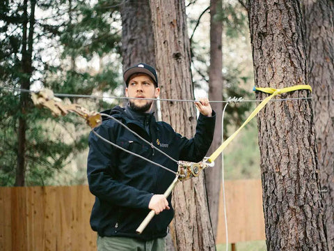 Man using Zip Line Tensioning Kit with Beefy 2 Ton Ratchet Winch, Cable Grab for Three Sixteenths to Three Quarters Inch Cable on trees.