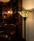 70 Inch Tiffany Torchiere Floor Lamp With Antique Mission Style Stained Glass Shade in a cozy library setting, amber glow
